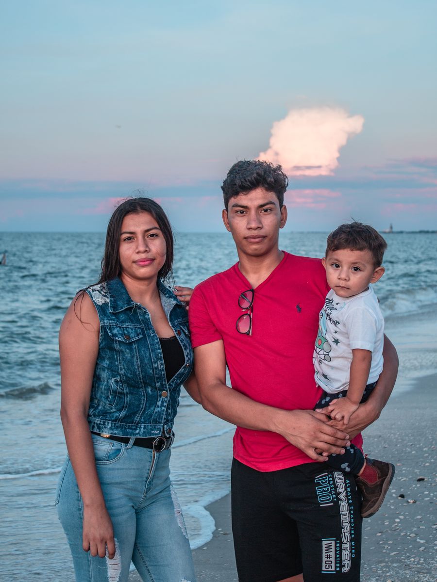 Young family with a toddler on the beach at dusk