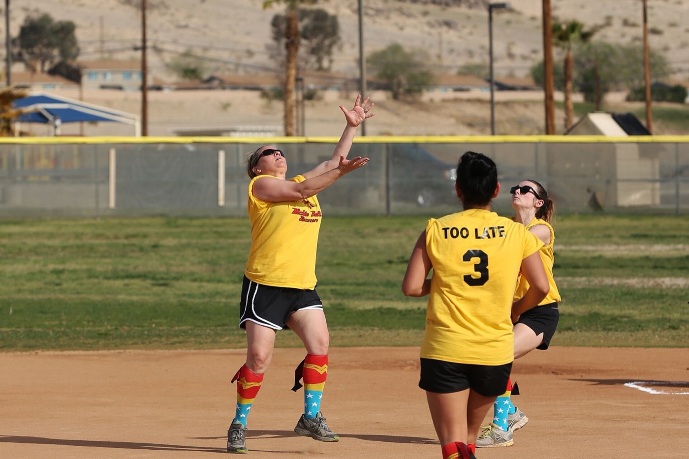 A crowd of teammates with arms up, celebrating a win